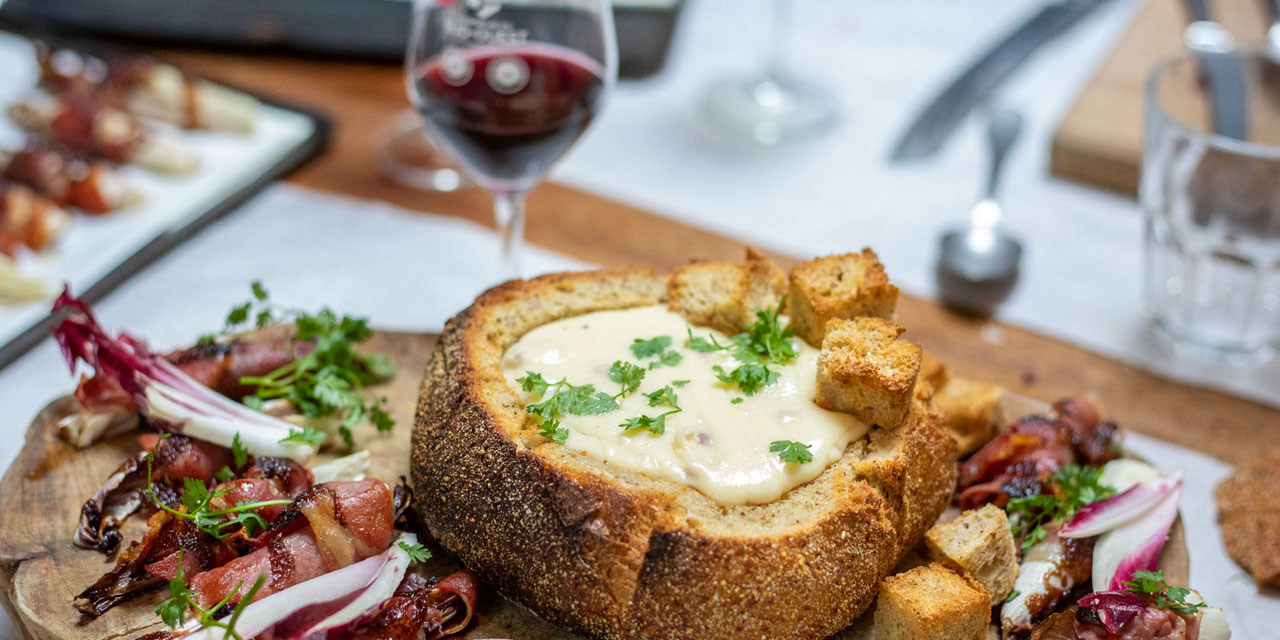 Fondue jambon de Bayonne et fromage de brebis dans une miche de pain au maïs & endives rôties au jambon de Bayonne