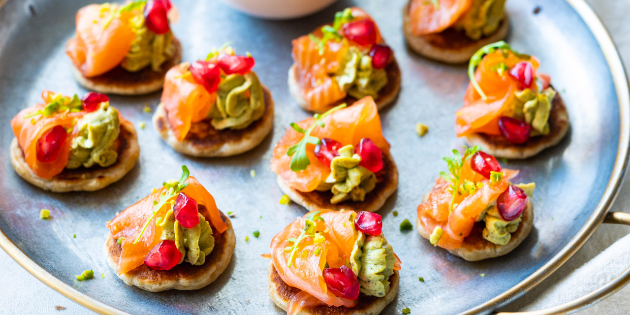 Mini blinis à la crème de pistache, truite fumée et grenade 